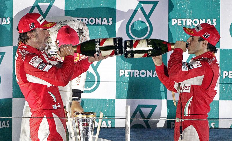 Ferrari Formula One driver Alonso of Spain and his team mate Massa of Brazil spray champagne as they celebrate on the podium after Alonso won the South Korean F1 Grand Prix at the Korea International Circuit in Yeongam