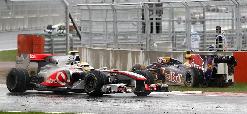 McLaren Formula One driver Hamilton of Britain drives past the crashed car of Red Bull Formula One driver Webber of Australia during the South Korean F1 Grand Prix at the Korea International Circuit in Yeongam