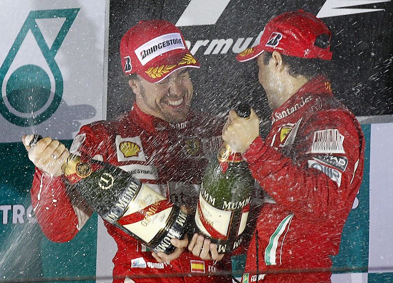 Ferrari Formula One driver Alonso of Spain and his team mate Massa of Brazil spray champagne as they celebrate on the podium after Alonso won the South Korean F1 Grand Prix at the Korea International Circuit in Yeongam