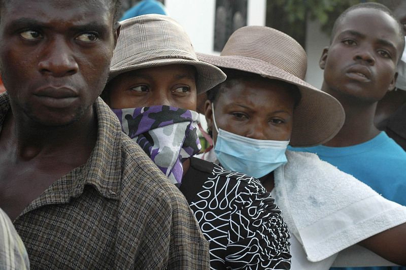 Relatives of Haitians suffering from cholera wait for news outside a local hospital in the town of Saint Marc