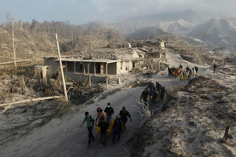 Volunteers carry the bodies of victims of Mount Merapi eruption at Kinarrejo village in Sleman