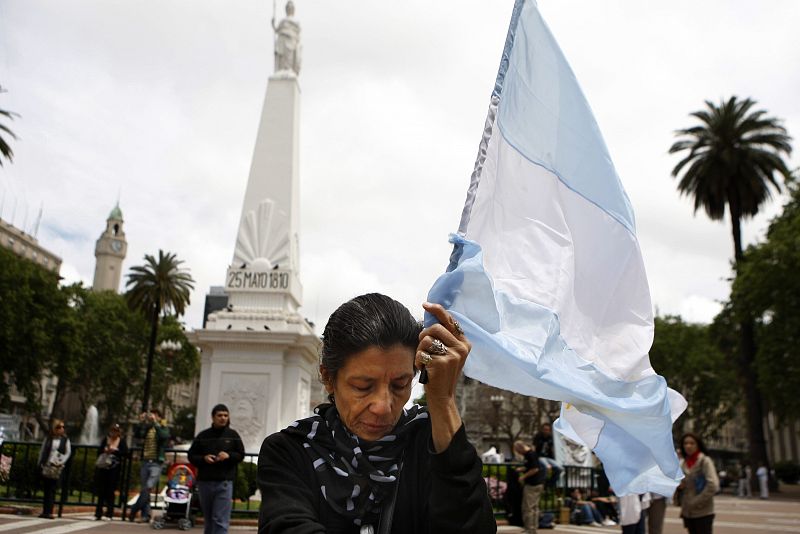 Una mujer que sostiene una bandera de Argentina muestra su pesar por la muerte de Kirchner