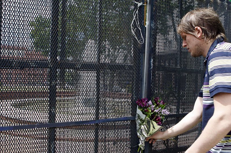 Un joven coloca un ramo de flores en una valla de la Plaza de Mayo, frente a la Casa Rosada en Buenos Aires (Argentina), en honor a Néstor Kirchner