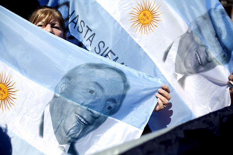 Una mujer sostiene una bandera nacional en la Plaza de Mayo.