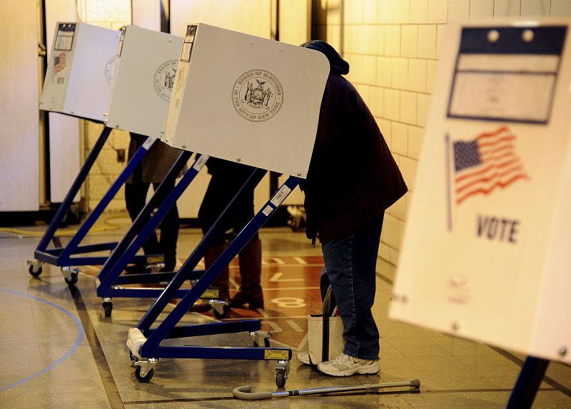 Varias personas votan a la vez en las máquinas electrónicas destinadas para ello en un colegio electoral del barrio Park Slope de Brooklyn, en Nueva York.