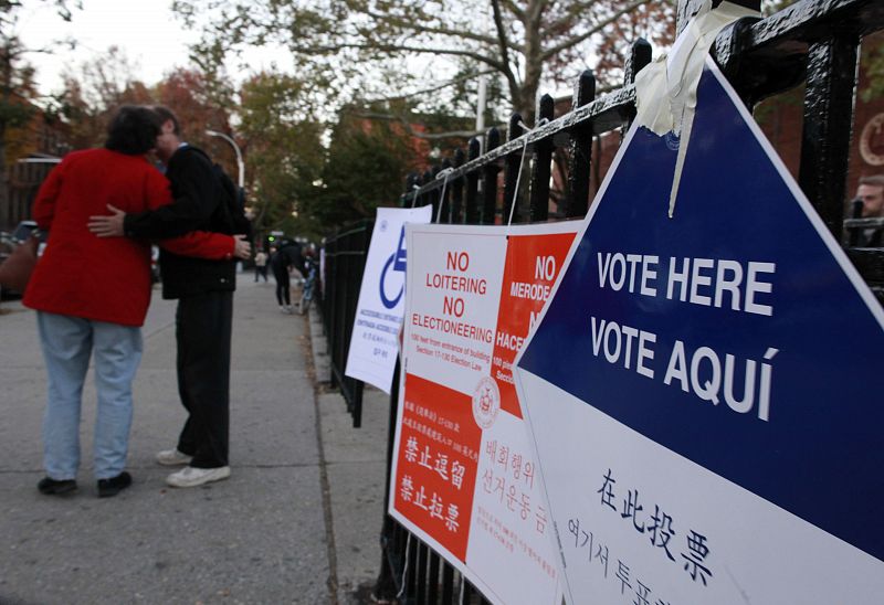 Carteles en varios idiomas, entre ellos en español, señalizan un colegio electoral.