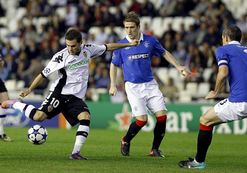 El centrocampista del Valencia Juan Manuel Mata intenta un disparo ante el centrocampista del Glasgow Rangers Stephen Davis.