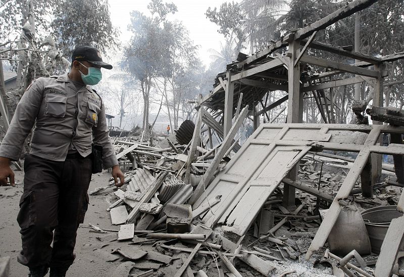 Las autoridades buscan víctimas entre los escombros de una casa destruida por las nubes de gas caliente, producto de la erupción del volcán Merapi.