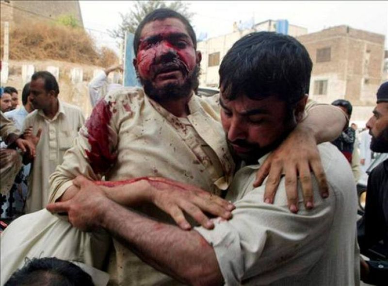 Un hombre herido sale de la mezquita tras el atentado ayudado por un ciudadano.