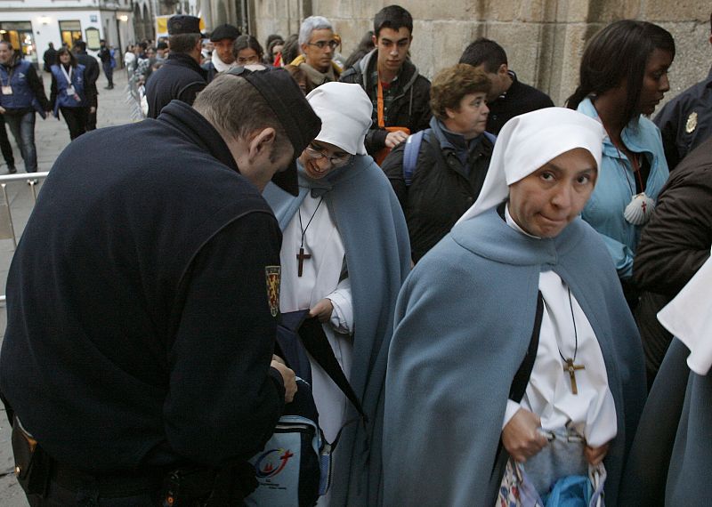 Un policía inspecciona la mochila de una religiosa en el acceso a la plaza del Obradoiro.