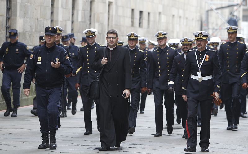 Una banda de música junto a un sacerdote llegan a la plaza del Obradoiro.