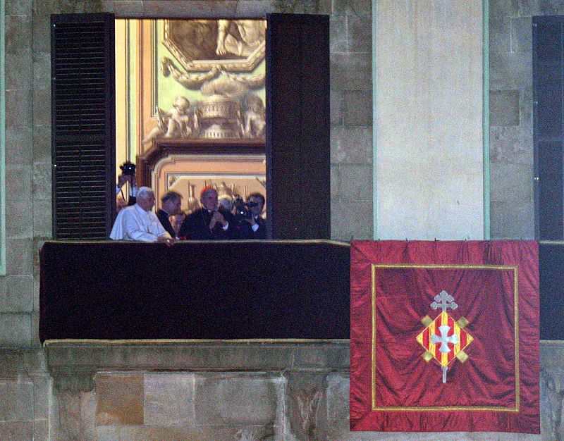 El papa Benedicto XVI (i), junto al arzobispo de Barcelona, Lluis Martínez Sistach, saluda a los fieles desde uno de los balcones del arzobispo. El Pontífice ha sorprendido así a centenares de personas que no esperaban recibir la bendición de Benedic