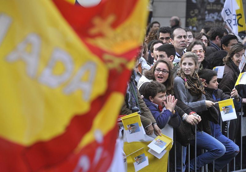 Un grupo de niños con banderas vaticanas esperan el paso del papa Benedicto XVI.