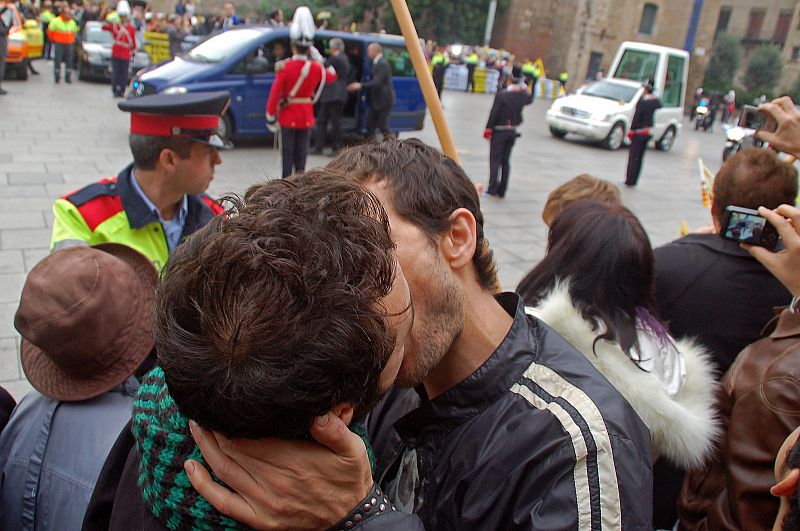 Dos homosexuales se besan al paso del papamóvil en una acción de protesta de gays y lesbianas por la visita del Papa.