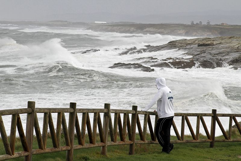 Un hombre observa el fuerte oleaje en Ribadeo (Galicia) debido a los fuertes vientos que han hecho decretar la alerta roja en el litoral gallego.