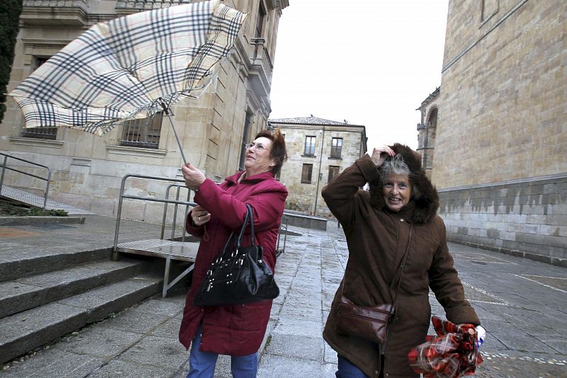 Los paraguas resultaban inservibles para protegerse de la lluvia hoy en Salamanca debido a las fuertes rachas de viento.