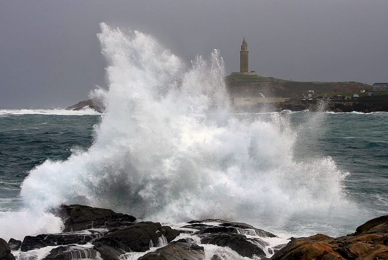 Una gran ola rompe contra las rocas del paseo marítimo de A Coruña, en la zona del Obelisco Milenium, durante una jornada marcada por la fuerte intensidad del viento.