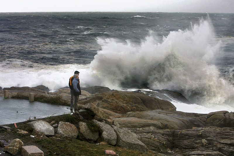 Una ola rompe contra las rocas del paseo marítimo en A Coruña debido al temporal que obligó a decretar la alerta roja en la costa gallega.