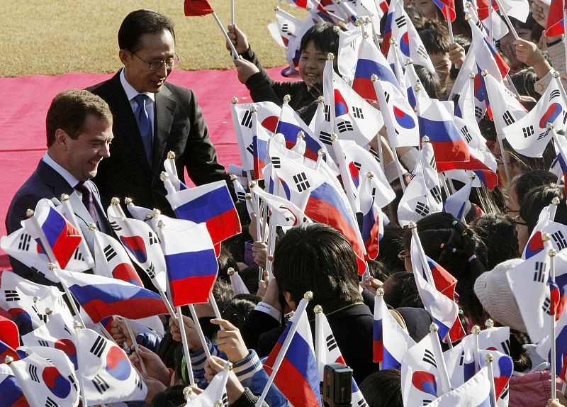 Russia's President Medvedev and South Korea's President Lee are greeted by South Korean students during a welcome ceremony at the presidential house in Seoul