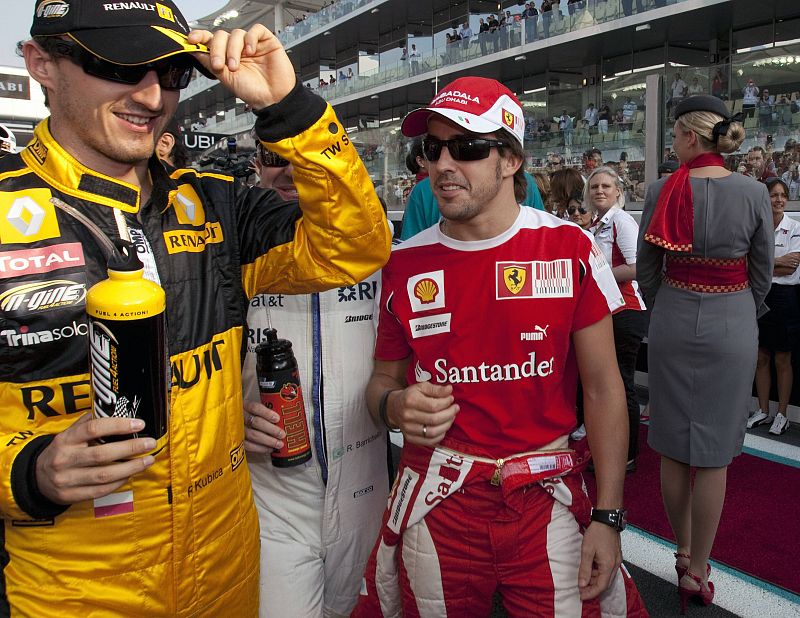 Alonso and Kubica wait after an end of season drivers' photograph before the Abu Dhabi F1 Grand Prix at Yas Marina circuit in Abu Dhabi