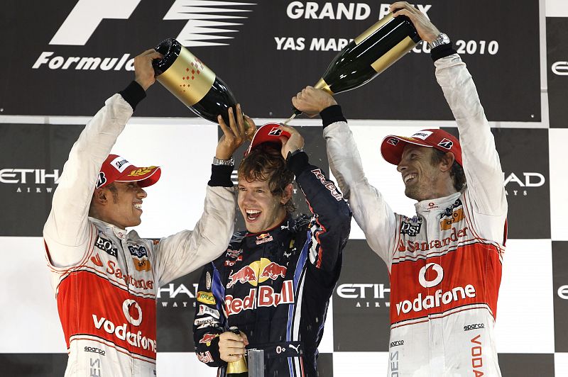 Red Bull Formula One driver Sebastian Vettel of Germany celebrates with Hamilton and Button after winning the Abu Dhabi F1 Grand Prix