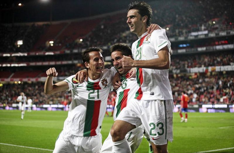Joao Pereira (i), Joao Moutinho (c) y Helder Postiga (d) celebran tras la anotación de un gol a España 