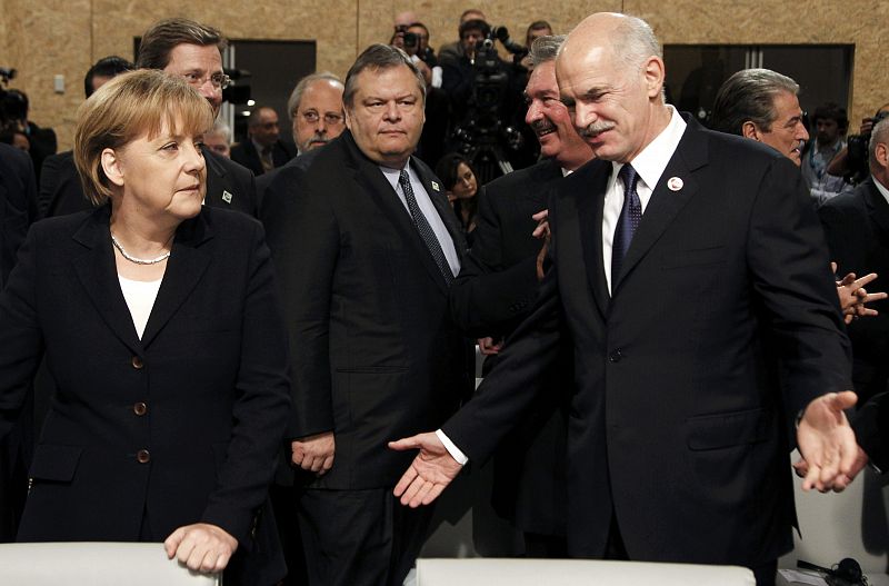 Greece's PM Papandreou gestures as German's Chancellor Merkel looks on during the second day of the NATO Summit in Lisbon