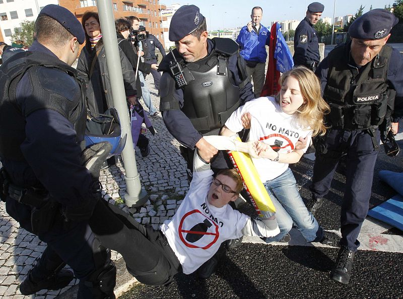 People are removed by police during a protest against the NATO summit in Lisbon