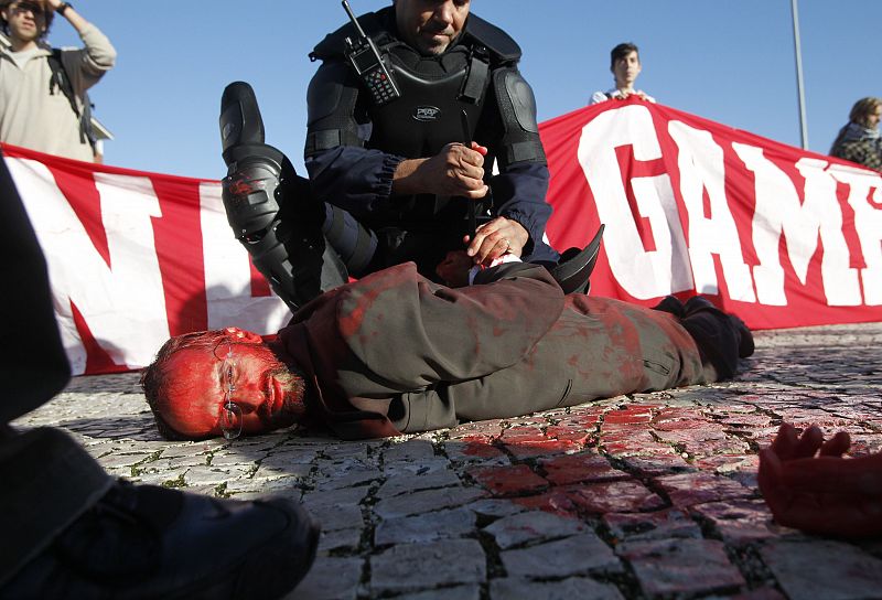 A man is tackled by police during protests against the NATO summit in Lisbon