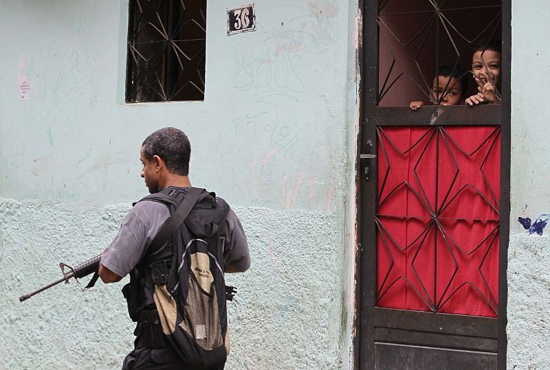 Dos niños observan atentos la operación policial que se ha desarrollado en su favela.