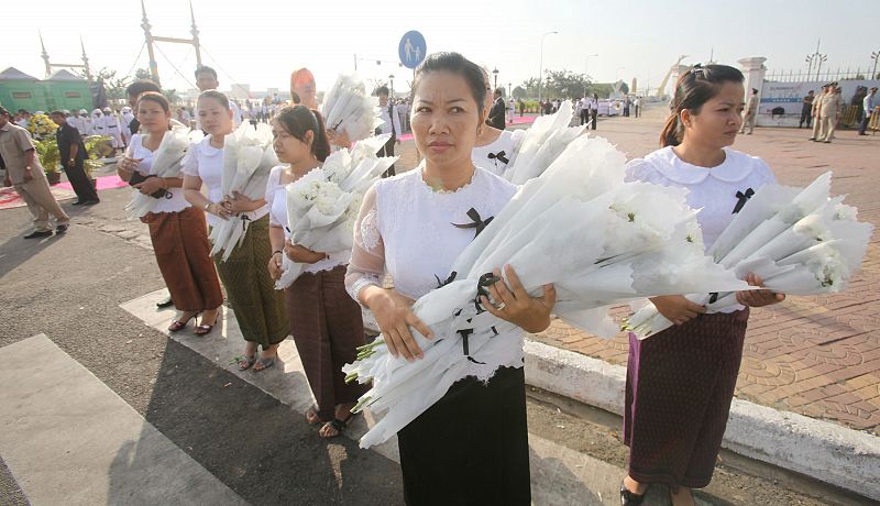 Varias mujeres portan flores para la despedida