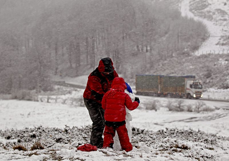 Varias personas hacen un muñeco de nieve en el alto de Ibañeta, en Roncesvalles.