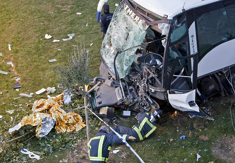 Los bomberos inspeccionan el autobús tras el accidente en el que 38 trabajadores han resultado heridos de diversa consideración.