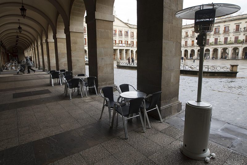 Una terraza de un bar, equipada con una estufa de exteriores permanece vacía en la Plaza de España de Vitoria, donde los termómetros apenas han rebasado los 4ºC.