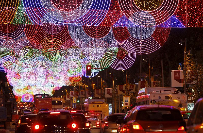 Vista de la calle Serrano de Madrid que luce un alumbrado navideño con un diseño formado por círculos, de estilo pop, ideado por la arquitecta Teresa Sapey.