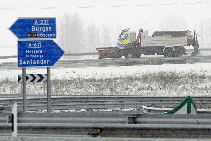 Una máquina quitanieves pasa por el cruce de la A-67 con la A-231 en Osorno (Palencia).