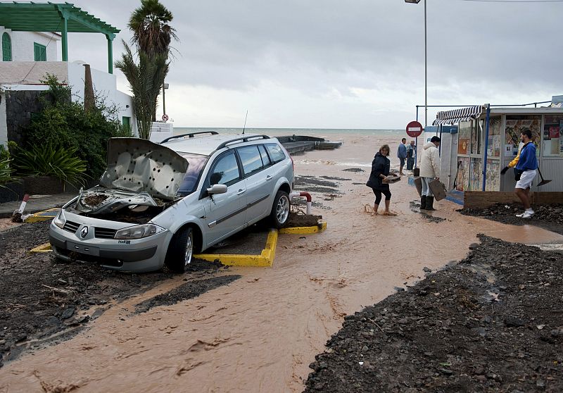 Vista de un coche que fue arrastrado por la fuerza del agua hacia las proximidades del mar en la localidad de Tuineje, en una jornada en la que las lluvias han golpeado fuerte a Fuerteventura.
