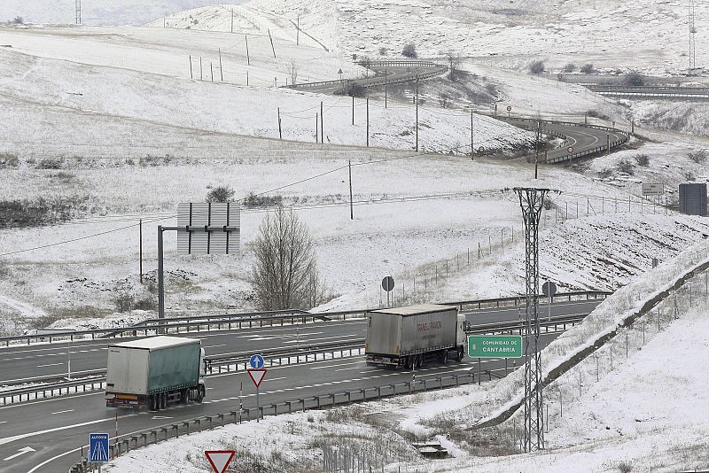Unos camiones circulan por la A-67 en el límite con Cantabria, donde la nieve no ha dejado de caer.