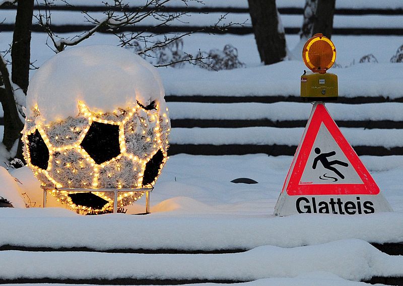 Una señal indica que la superficie es resbaladiza frente a la sede de la FIFA en Zúrich (Suiza), donde siguen las presentaciones de los países candidatos a albergar el Mundial de fútbol de 2018.