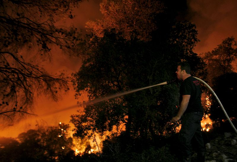 Un bombero lucha contra las llamas en el bosque Carmel.