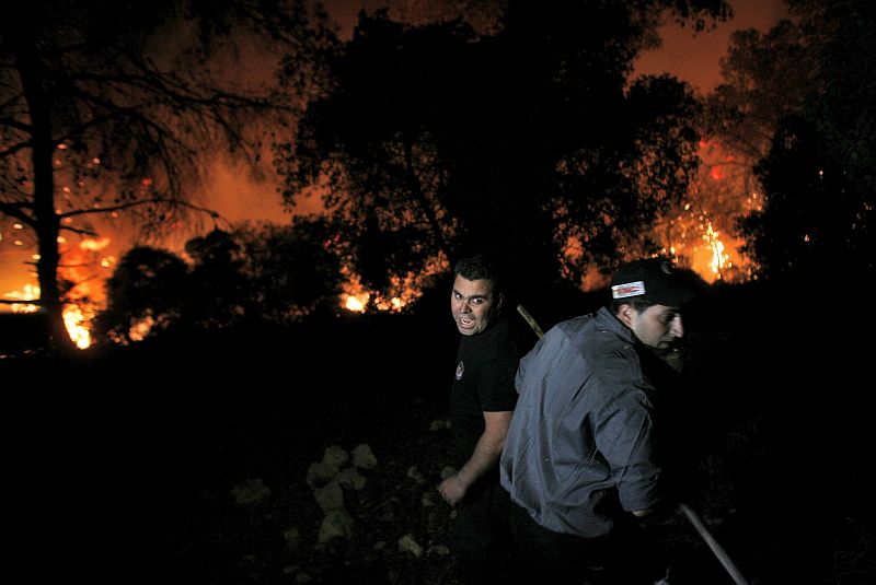 Policía, bomberos, y equipos de voluntarios suman esfuerzos para tratar de extinguir el incendio.