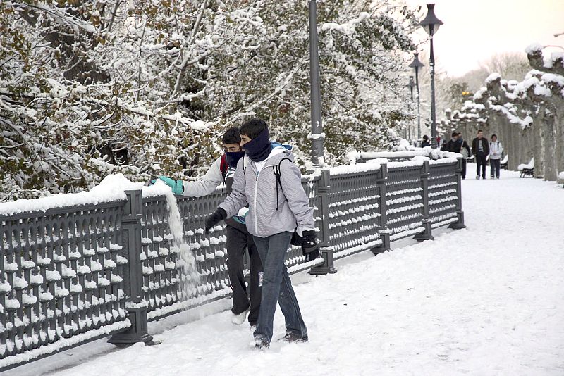 Estudiantes de instituto camino de clase por la orilla del rio Carrion, esta mañana, tras la intensa nevada de la noche que ha cubierto la ciudad de Palencia.