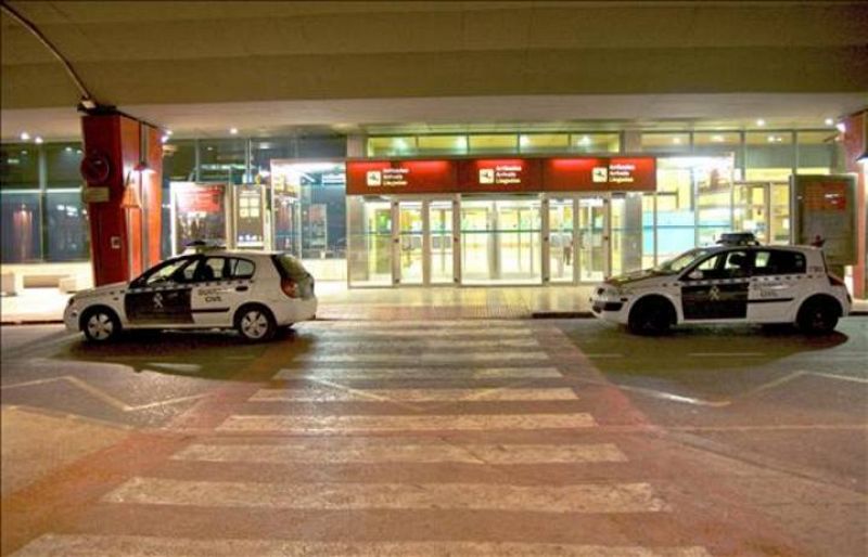 Dos coches de la Guardia Civil permanecen en una de las entradas del aeropuerto de Manises (Valencia), que se mantiene abierto pero ha dejado de operar por el cierre del espacio aéreo y después de que los controladores hayan solicitado bajas de sus p