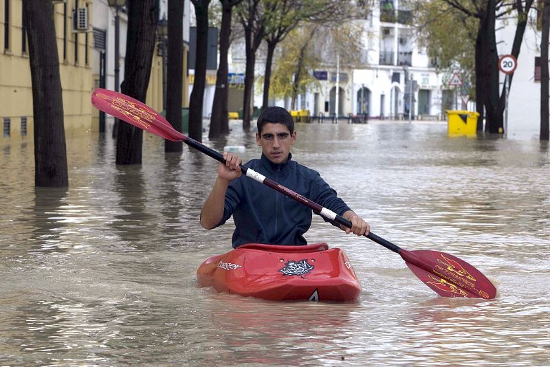 Un joven se desplaza con una piragua por las calles de Écija (Sevilla) donde un treinta por ciento del casco urbano , con unos 40.000 habitantes, se encuentra inundado debido a las intensas lluvias de las últimas horas