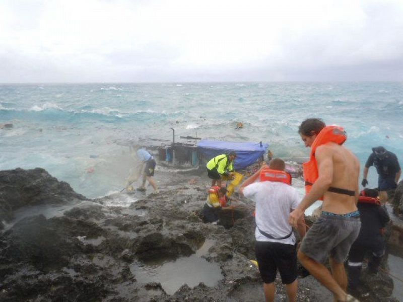 Miembros de los servicios de rescate prestan ayuda a los ocupantes del barco accidentado