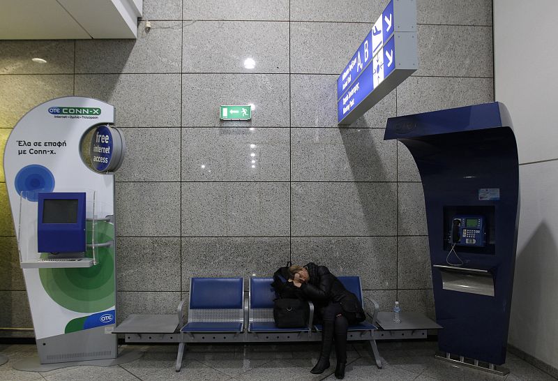 Un pasajero duerme en el aeropuerto internacional de Atenas durante la octava huelga general del año que se celebra en Grecia