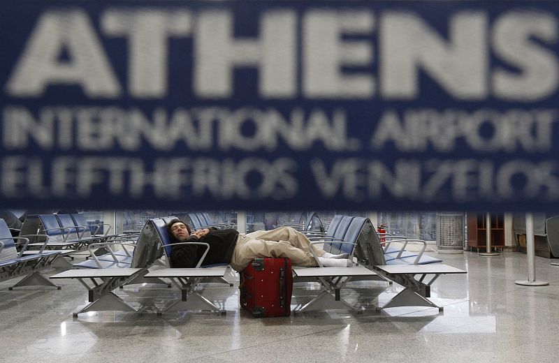 Un pasajero duerme en el aeropuerto de Atenas durante la huelga general de Grecia