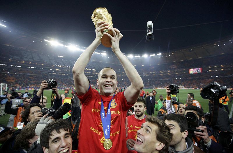 Andrés Iniesta, goleador en la final del Mundial 2010, levanta la copa del Mundo a la vez que es levantado por sus compañeros de la selección.