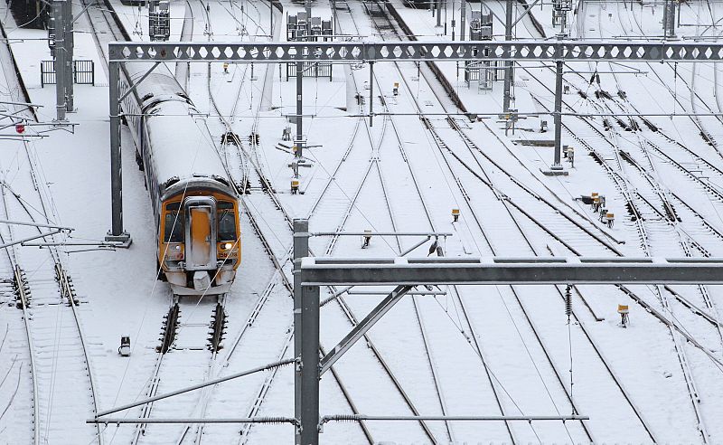 A train travels over snow covered tracks as it leaves Waverly Station in Edinburgh, Scotland