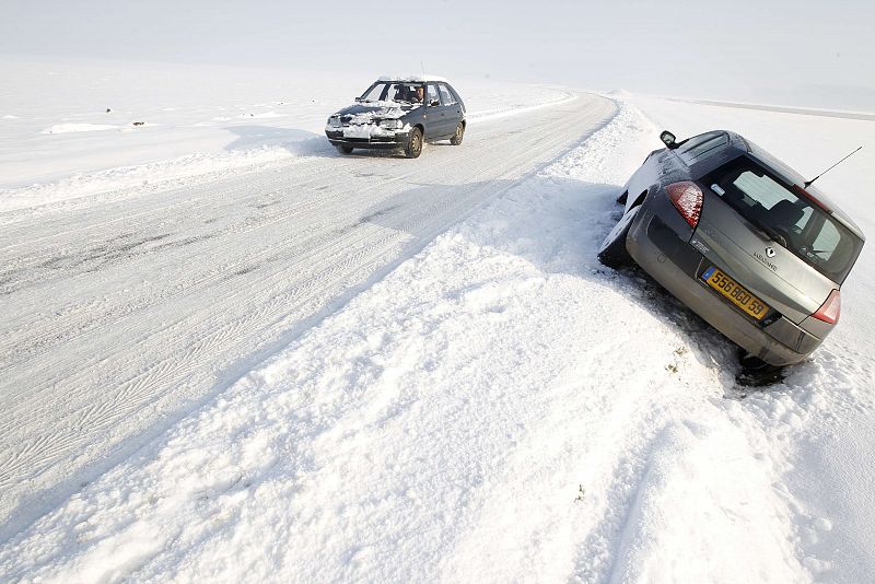 Un coche se ha quedado atascado en una zanja a lo largo de un camino cubierto de nieve en Féchain cerca de Cambrai en Francia.